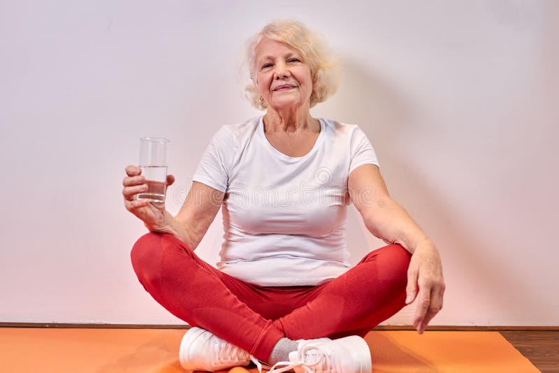 mature caucasian woman drinking fresh water after yoga exercises royalty free stock photography