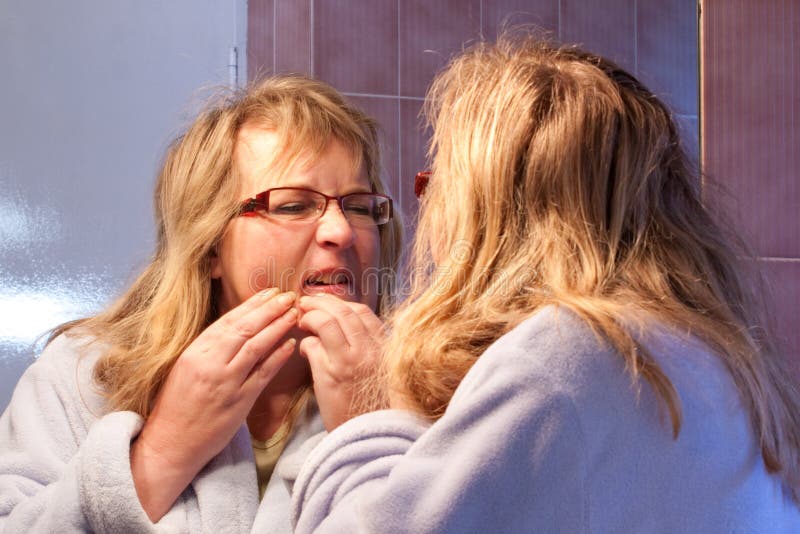 Mature woman squeezing pimple