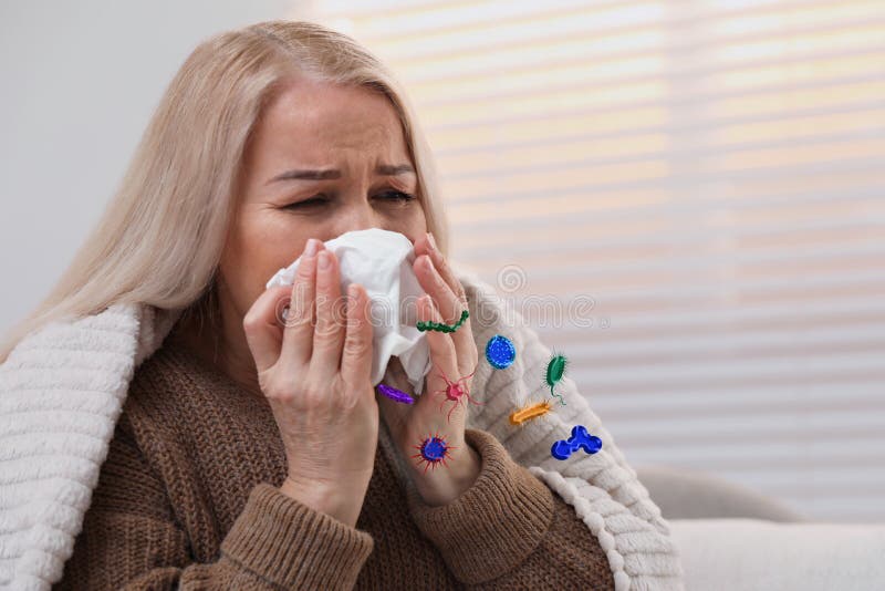 Mature woman suffering from cold at home. Microbes spreading stock images