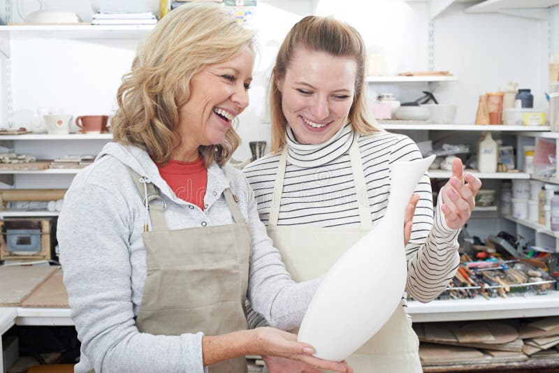 Mature Woman with Teacher Looking at Vase in Pottery Class Stock Image