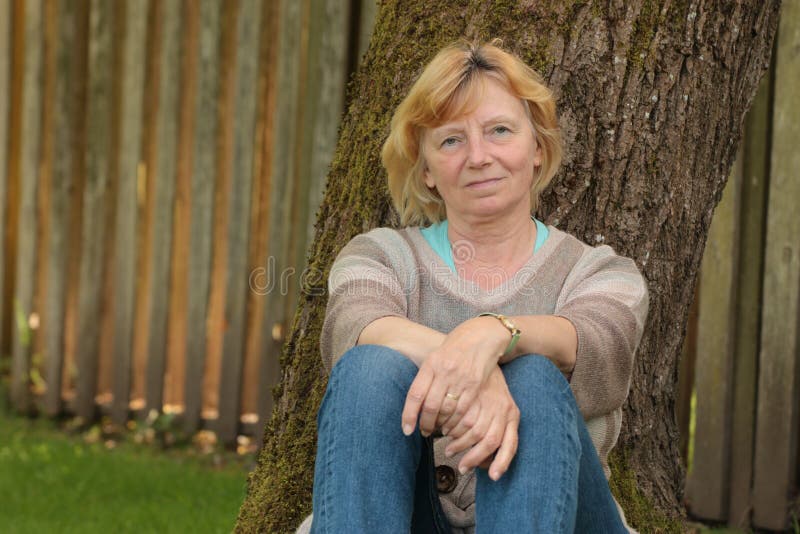 Mature woman under tree stock image. Image of relax, fence - 53560523