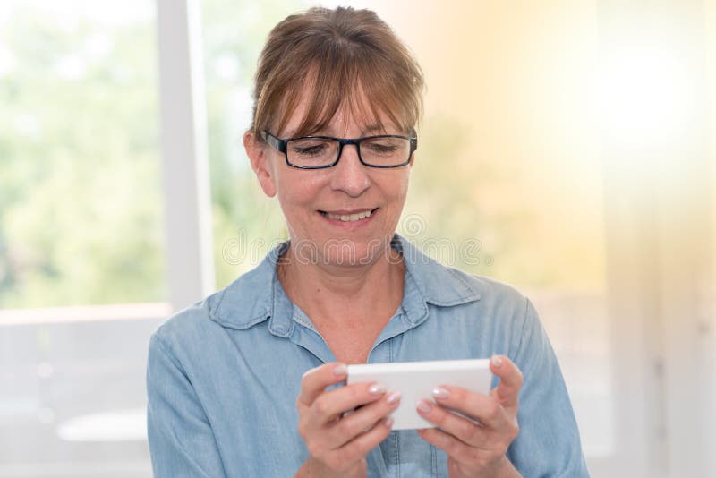 Mature Woman Using Her Mobile Phone, Light Effect Stock Image Image