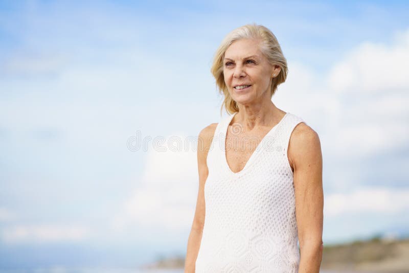 Mature Woman Walking on the Beach. Elderly Female Standing at a Seaside ...