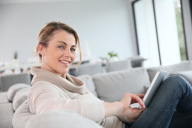 Mature woman websurfing with tablet at home