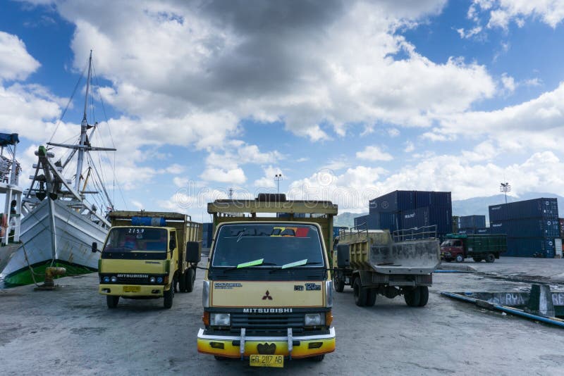 MAUMERE/INDONESIA-APRIL 28 2014: Three trucks carrying goods were parked in the port of Maumere on a clear day, waiting for the royalty free stock photo MAUMERE/INDONESIA-APRIL 28 2014: Three trucks carrying goods were parked in the port of Maumere on a clear day, waiting for the royalty free stock photo