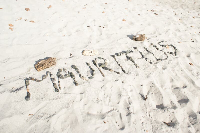 Mauritius written in pebbles on a sandy beach