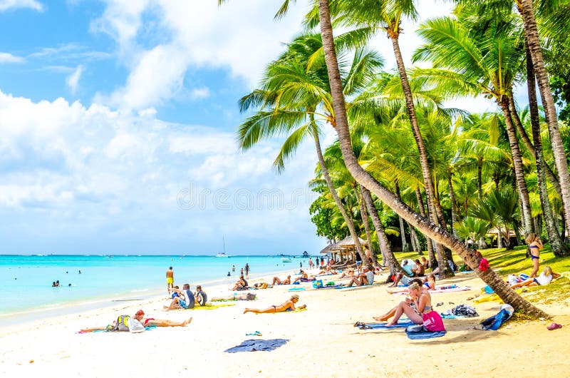 MAURITIUS - NOVEMBER 03, 2019: Sunny holiday in tropical paradise. Blue sea and sky, white sand beach and green palm