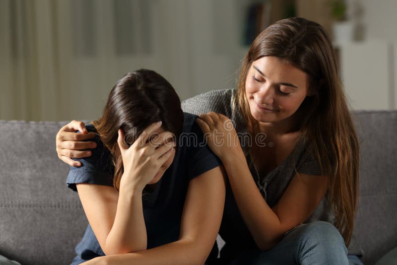 Mauvais ami d'hypocrite soulageant une fille triste images libres de droits Mauvais ami d'hypocrite soulageant une fille triste images libres de droits