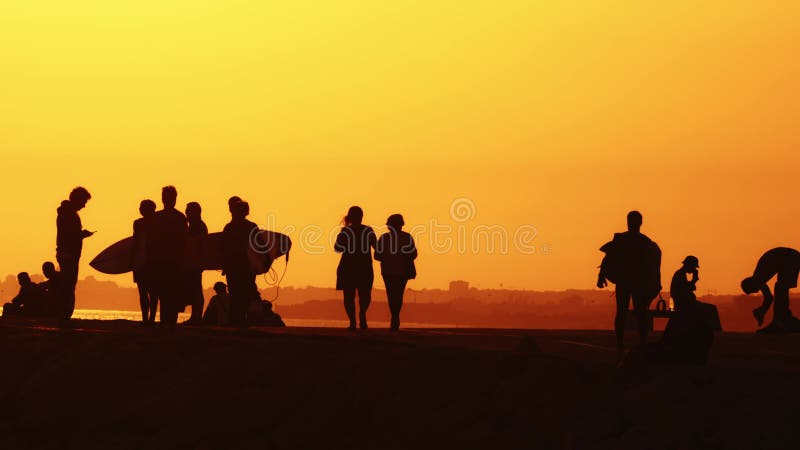 24 may 2023, Costa da Caparica, Portugal: silhouettes of people holding surfboards on the hill at sunset