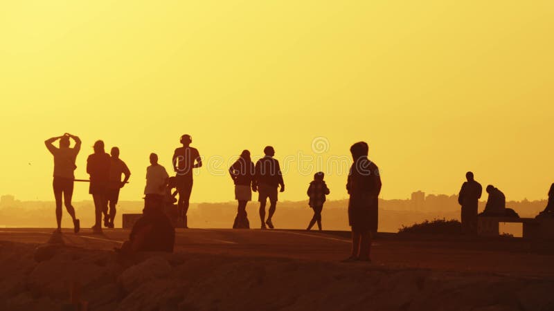 24 may 2023, Costa da Caparica, Portugal: silhouettes of young people on the hill at sunset