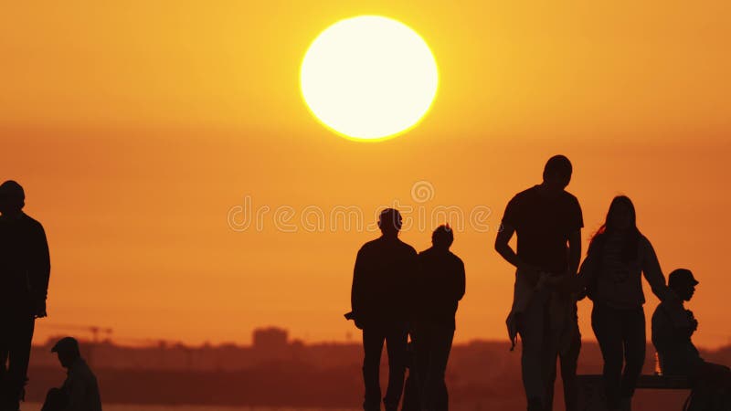 24 may 2023, Costa da Caparica, Portugal: silhouettes of youth at bright orange sunset