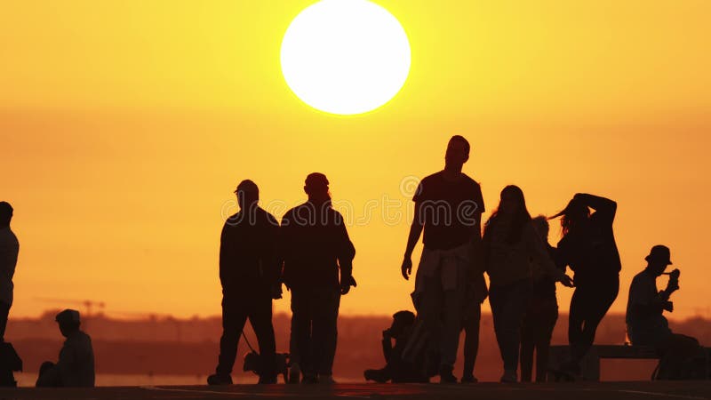 24 may 2023, Costa da Caparica, Portugal: silhouettes of youth at bright sunset