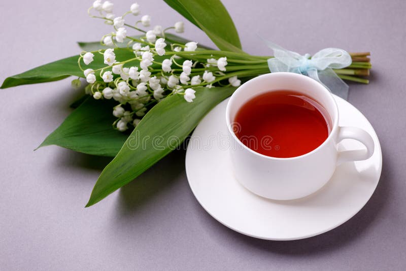 May Lily blommor med tekopp i grå bakgrund Ögontidsbukett Bakgrund för Florens Blommor, våren, sommaren royaltyfri fotografi May Lily blommor med tekopp i grå bakgrund Ögontidsbukett Bakgrund för Florens Blommor, våren, sommaren royaltyfri fotografi