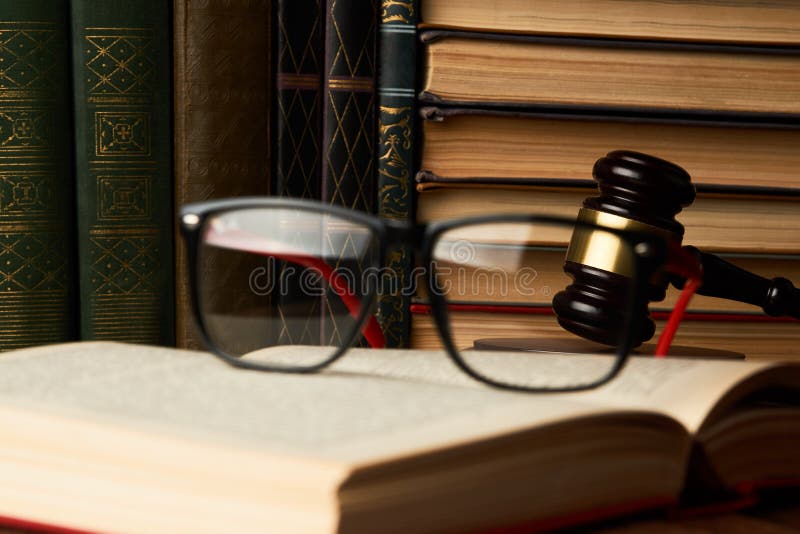 Mazo del juez y colección de libros legal con las lentes en de madera imagen de archivo Mazo del juez y colección de libros legal con las lentes en de madera imagen de archivo