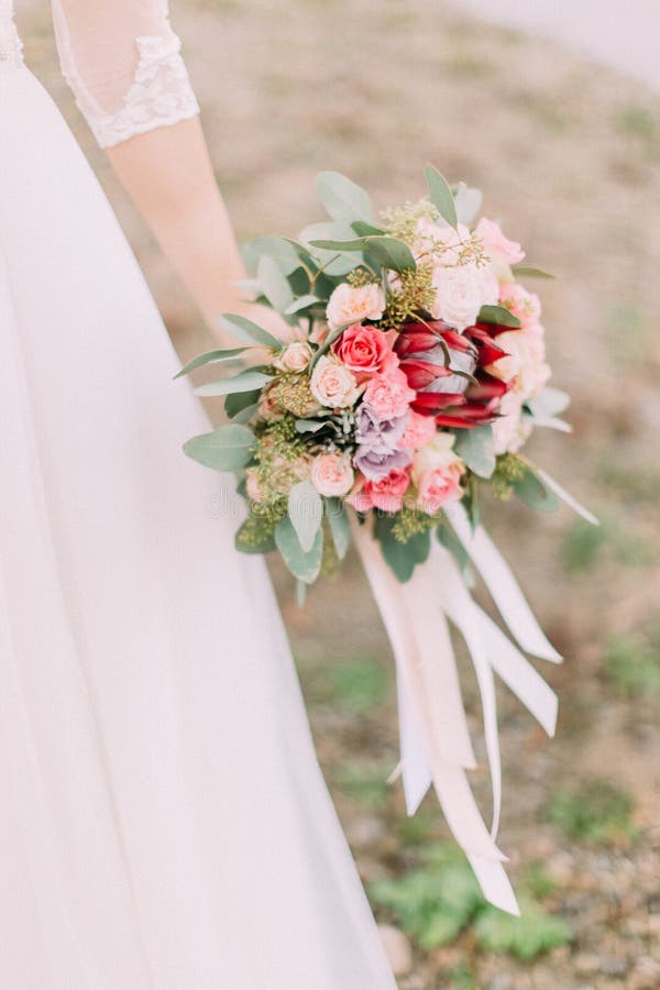 Mazzo colourful del primo piano dei fiori esotici nella mano della sposa fotografia stock libera da diritti
