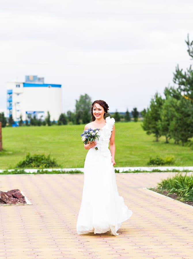 Mazzo della tenuta della sposa delle calle bianche e dei fiori blu fotografie stock Mazzo della tenuta della sposa delle calle bianche e dei fiori blu fotografie stock