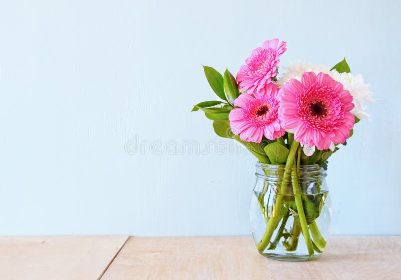 Summer bouquet of flowers on the wooden table with mint background. vintage filtered image . Summer bouquet of flowers on the wooden table with mint background. vintage filtered image .