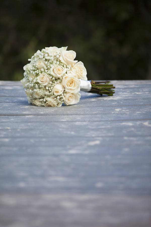Bridal bouquet on sandy deck at beach wedding. Bridal bouquet on sandy deck at beach wedding