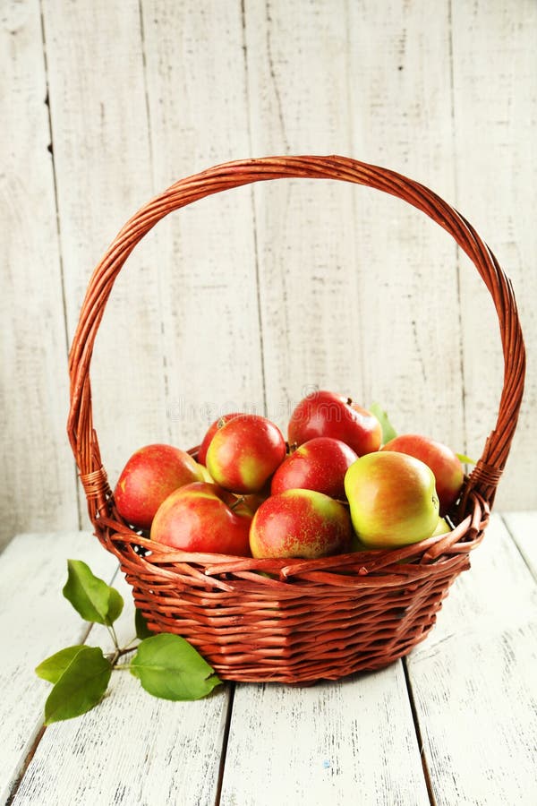 Maçãs bonitas na cesta no fundo de madeira branco imagens de stock