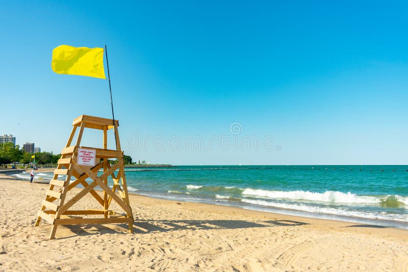 Maître nageur Tower avec le drapeau jaune sur une plage de Chicago semblant du nord photo stock Maître nageur Tower avec le drapeau jaune sur une plage de Chicago semblant du nord photo stock