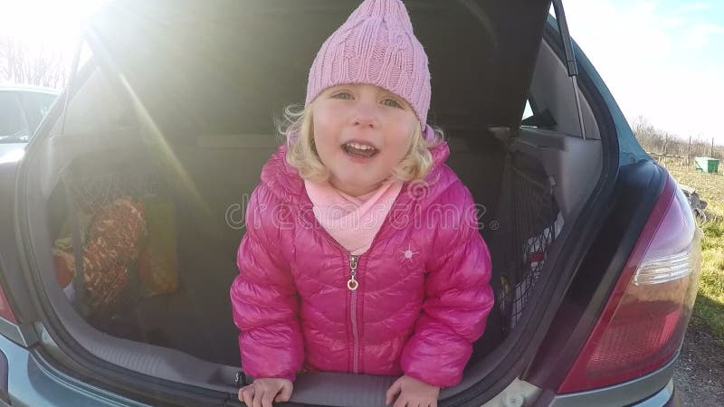 Mała dziewczynka bawić się w samochodu bagażnika wideo