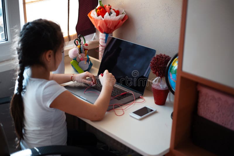 Mała dziewczynka robi jej pracie domowej na laptopie obrazy stock Mała dziewczynka robi jej pracie domowej na laptopie obrazy stock