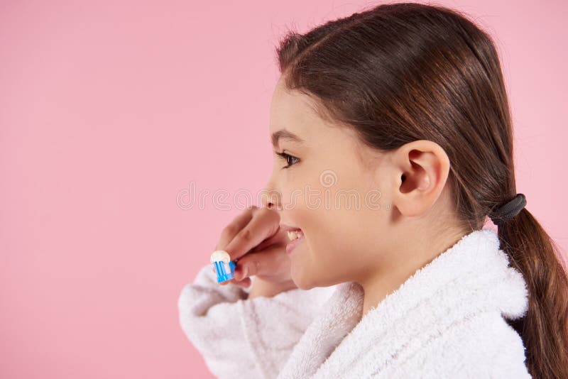 Mała dziewczynka w bathrobe szczotkuje zęby fotografia royalty free Mała dziewczynka w bathrobe szczotkuje zęby fotografia royalty free