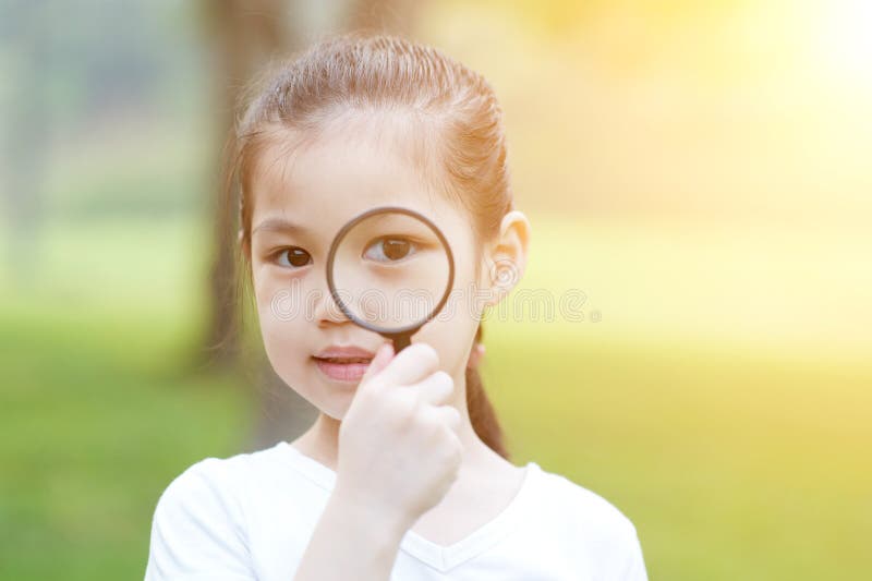 Mała dziewczynka z magnifier szkłem przy outdoors zdjęcie stock Mała dziewczynka z magnifier szkłem przy outdoors zdjęcie stock