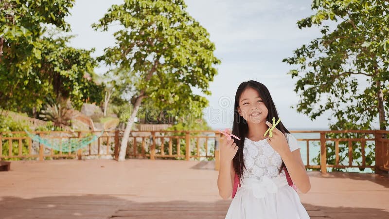 Mała filipińska uczennica pokazuje przędzalnianych kądziołków tropikalny krajobrazu Lato Dzieciństwo
