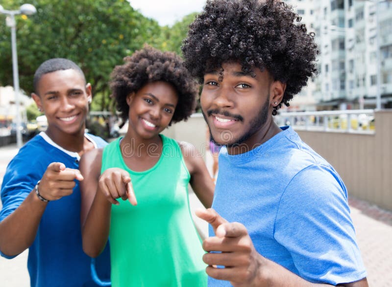 Small group of african american men and women pointing at camera outdoor in the city in the summer. Small group of african american men and women pointing at camera outdoor in the city in the summer