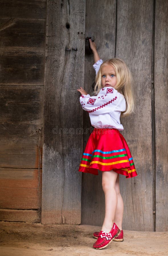 Mała ukraińska dziewczyna blisko drewnianego drzwi