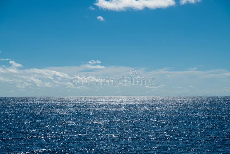 Małe chmury na niebieskim niebie nad jasną, musującą wodą oceanu północnego atlantyckiego obraz stock