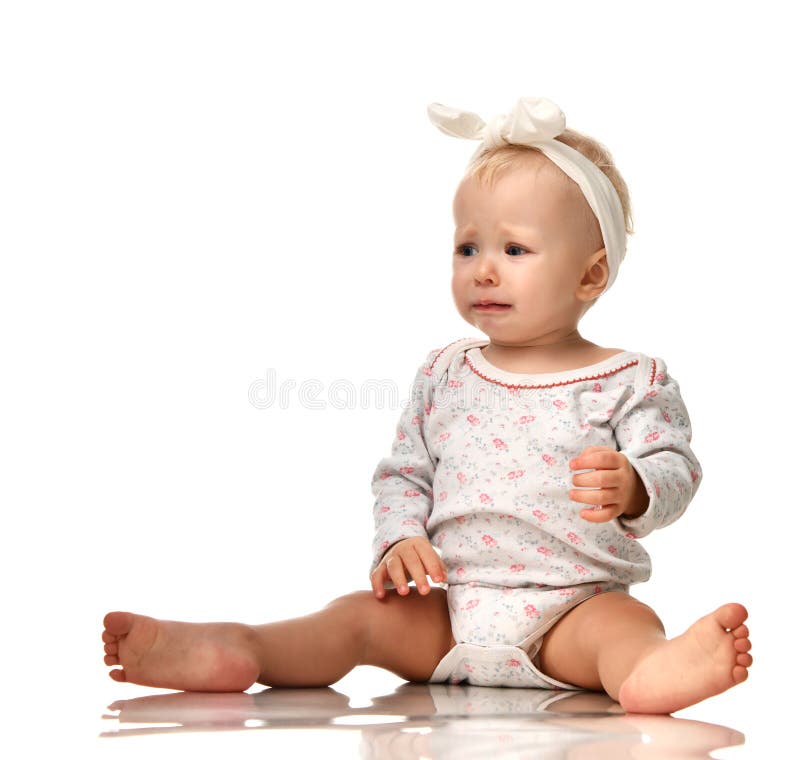 Small infant child baby girl toddler sad crying screaming isolated on a white background. Small infant child baby girl toddler sad crying screaming isolated on a white background