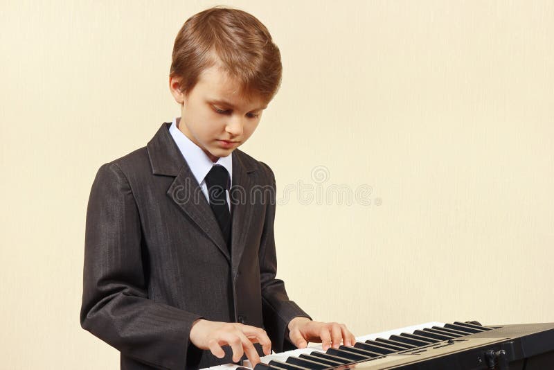 Mały beginner muzyk w kostiumu bawić się syntetyka obraz stock Mały beginner muzyk w kostiumu bawić się syntetyka obraz stock