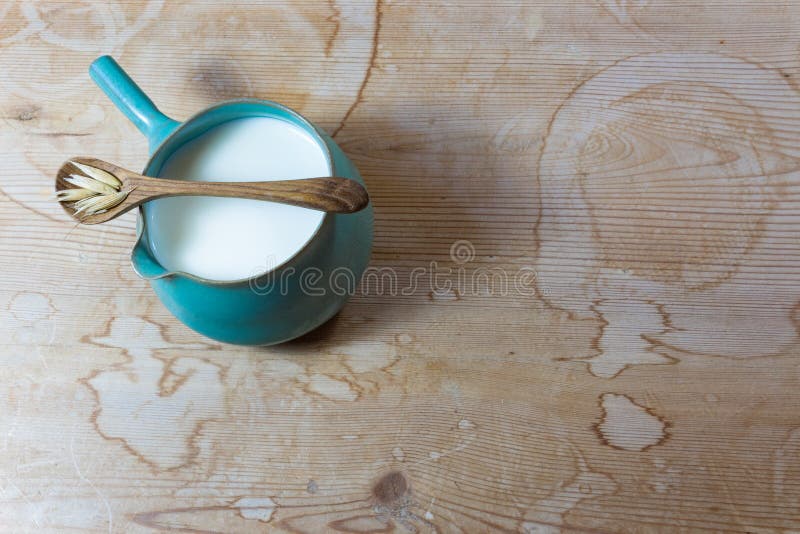 Mały ceramiczny boczny rękojeść miotacz wypełniał z owsa mlekiem, drewniana łyżka z wysuszonymi owsami obraz stock Mały ceramiczny boczny rękojeść miotacz wypełniał z owsa mlekiem, drewniana łyżka z wysuszonymi owsami obraz stock