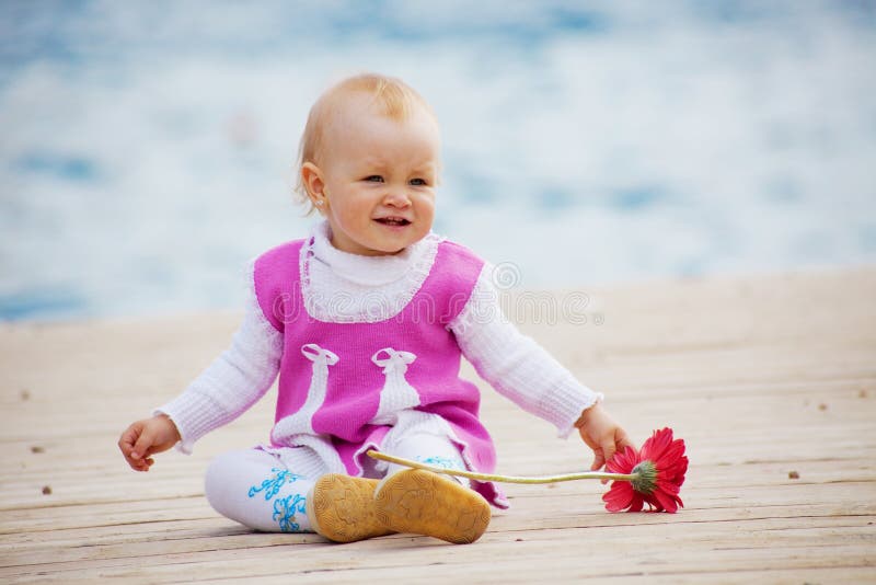 Portrait of little cute baby girl with flower on berth near sea. Portrait of little cute baby girl with flower on berth near sea