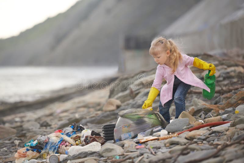 Little janitor picking up garbage at the beach. Little janitor picking up garbage at the beach.