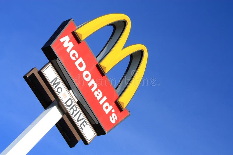 McDonalds sign on blue sky background. McDonald's Corporation is the world's largest chain of hamburger fast food restaurants, serving more than 58 million customers daily.