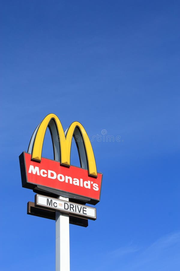 McDonalds sign on blue sky background. McDonald's Corporation is the world's largest chain of hamburger fast food restaurants, serving more than 58 million customers daily. McDonalds sign on blue sky background. McDonald's Corporation is the world's largest chain of hamburger fast food restaurants, serving more than 58 million customers daily.