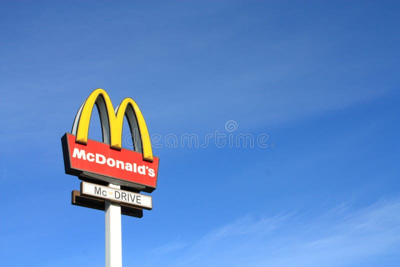 McDonalds sign on blue sky background. McDonald's Corporation is the world's largest chain of hamburger fast food restaurants, serving more than 58 million customers daily. McDonalds sign on blue sky background. McDonald's Corporation is the world's largest chain of hamburger fast food restaurants, serving more than 58 million customers daily.