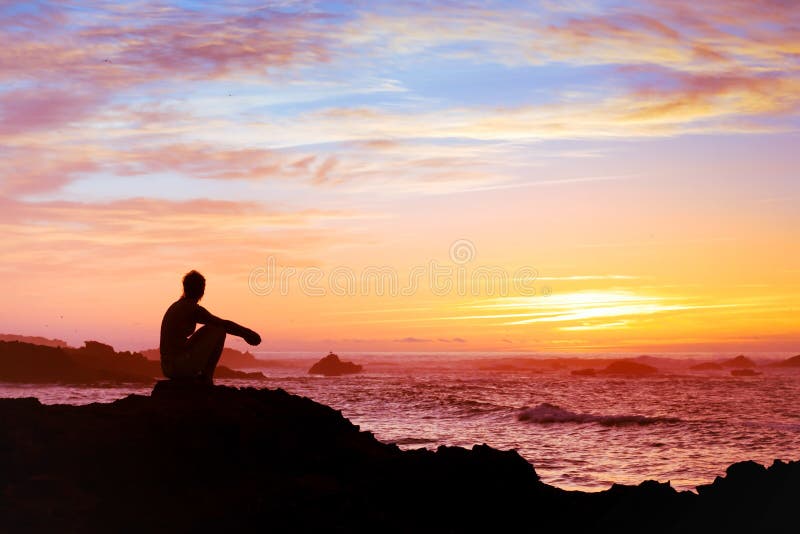 Žena sedí sám na západ slunce u moře, relaxaci a přemýšlení o smyslu života.