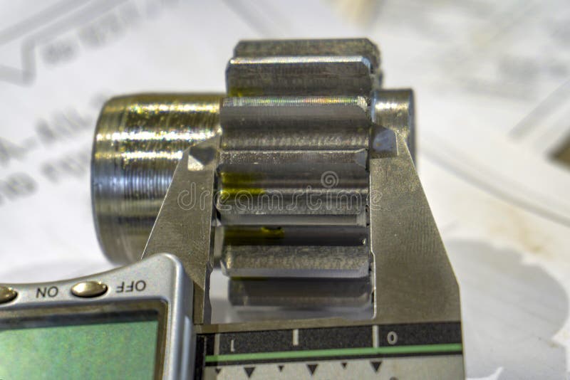 Measuring gears with a caliper in production, high-precision machining stock images