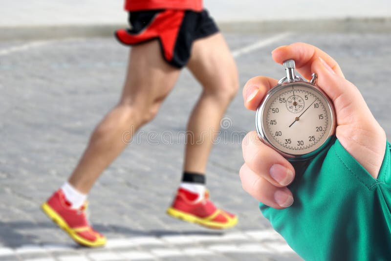 Premium Photo  Measuring the running speed of an athlete using a  mechanical stopwatch hand with a stopwatch on the background of the legs of  a runner feet running