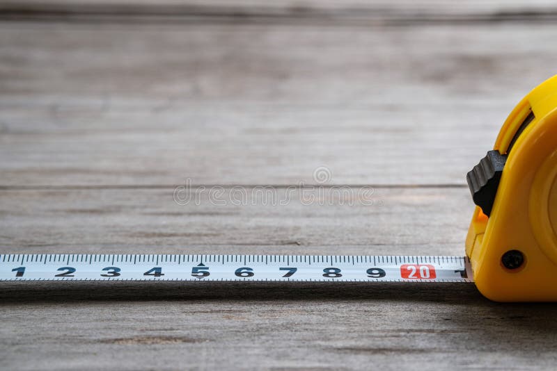 Measuring tape stretched 21 cm on a wooden background. Close-up