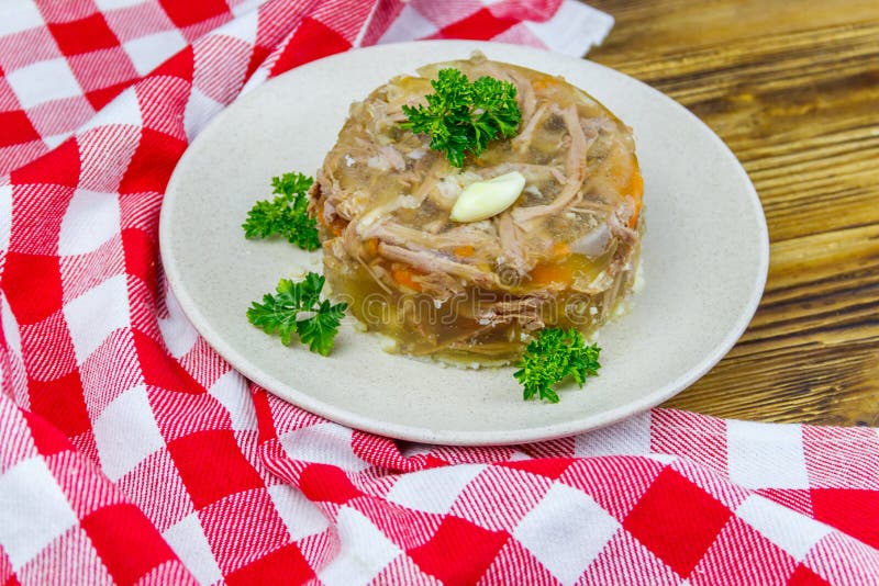 Meat Aspic in a Plate on Wooden Table. Traditional Russian Dish Stock