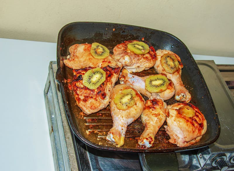 Meat with Kiwi Fruit. Fried Chicken Pieces with Kiwi Slices on a Grill