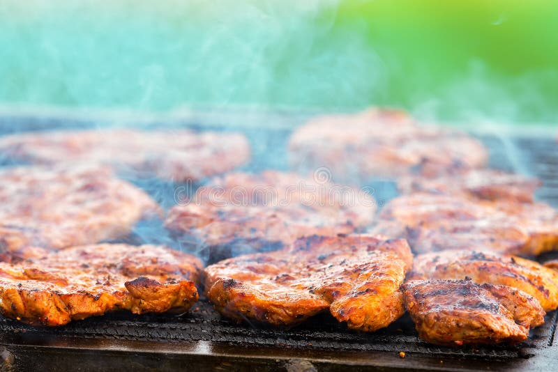Meat Pork Steak on a Hot Grill BBQ with Smoke and Fire Stock Photo
