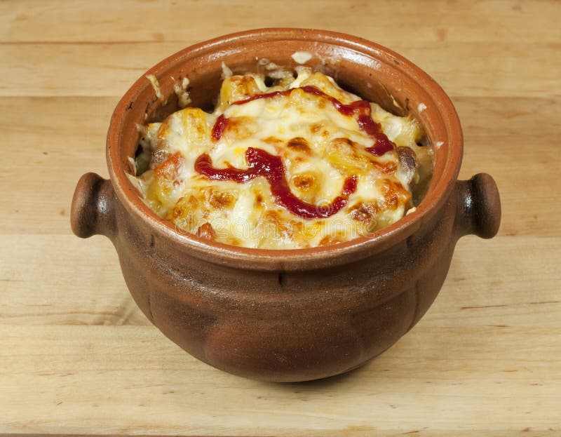 Meat and vegetables with cheese and ketchup in a pot