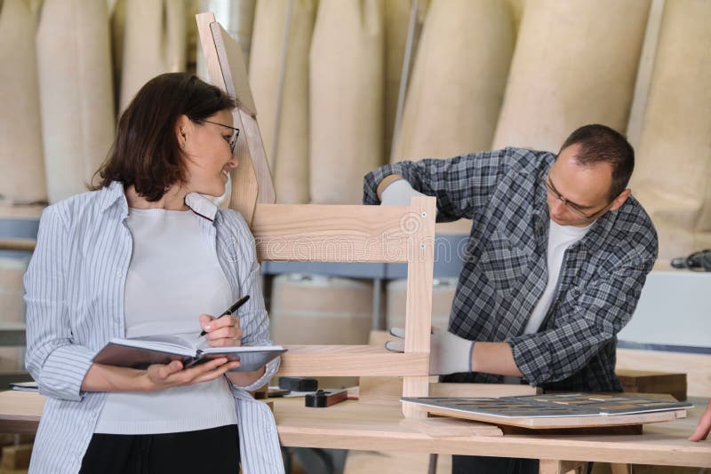 Meblarska joinery produkcja, pracuj?cy m?ski joiner i kobiety w?a?ciciel biznesu z notatnikiem, zdjęcia royalty free Meblarska joinery produkcja, pracuj?cy m?ski joiner i kobiety w?a?ciciel biznesu z notatnikiem, zdjęcia royalty free