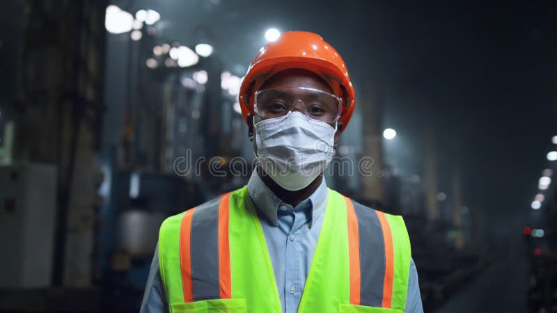 Mecanic cu mască de față care se uită la camera foto a fabricii fabricii. stock images